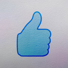 thumb up like symbol on a gray wall background