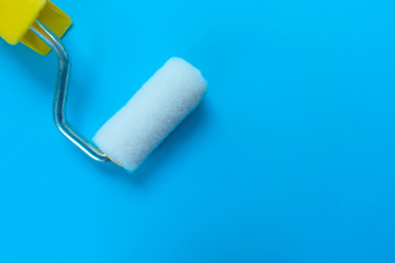  Paint roller isolated on blue background. Copy space.