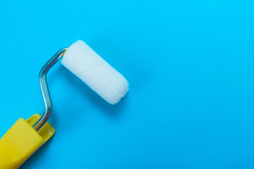  Paint roller isolated on blue background. Copy space.