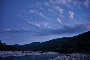 Fototapeta premium Blue sky with light clouds at dawn in the mountains. Abstract blue background.