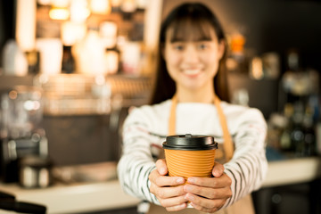 Young asian women barista hold coffee cup serving a client at the coffee shop,start up small business owner food and drink concept..