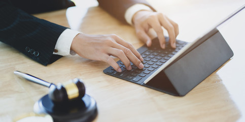 Lawyer working on a laptop and providing legal document for his client