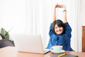 Young woman or student using laptop sitting at coffee shop. Happy girl working online or studying and using notebook. Freelance business concept.