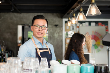 Young asian men barista smiling at coffee shop counter background, start up small business owner food and drink concept.