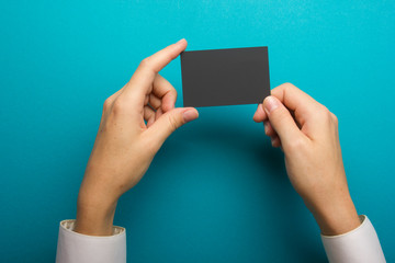 Hand holding business card blank on abstract background