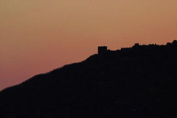 Beautiful view on the mountain of Alanya with silhouette of Red tower at sunset time