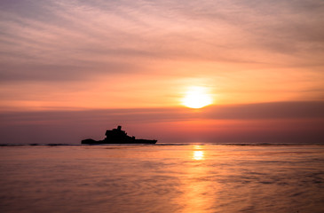 Fototapeta na wymiar Abandoned ship in the sea during sunset