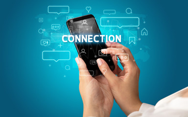 Female hand typing on smartphone with CONNECTION inscription, social media concept