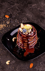 Vegan pancakes based avocado with cocoa and date syrup. Vegan healthy sweet food. Dark background