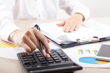 Close up of female accountant or banker making calculations. Savings, finances and economy concept