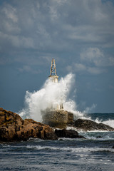 Big waves hit the old lighthouse. Sea storm with big waves. Weather forecast. 