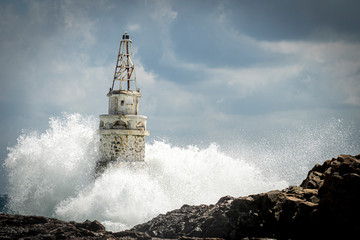 Big waves hit the old lighthouse. Sea storm with big waves. Weather forecast. 