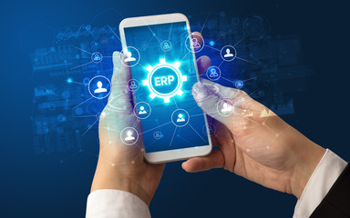 Female hand holding smartphone with ERP abbreviation, modern technology concept