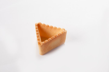 The triangular shape of the tartlet from unleavened dough to fill with different fillings. The concept of cooking snacks. Photo on a white background. Isolated object. View from above.