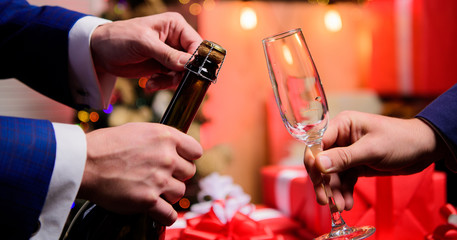 Last minute before new year. New year countdown. Hands opening champagne bottle and hold glass christmas decorations background. Drink champagne or sparkling wine. Celebrate new year with champagne