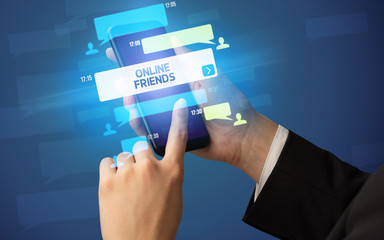 Female hand typing on smartphone with ONLINE FRIENDS inscription, social networking concept