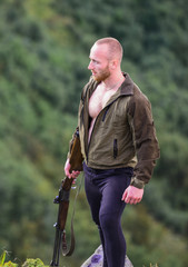 Illegal hunting. Man brutal poacher with weapon natural landscape background. Poaching concept....