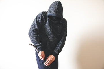 Criminal with crowbar near the doors. Robber in dark hoodie.