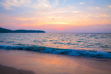 sunset on the sea. sandy beach, clear water, waves. surf line in the warm colors of the setting sun.