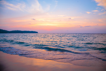 sunset on the sea. sandy beach, clear water, waves. surf line in the warm colors of the setting sun.