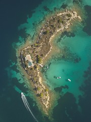 Fototapeta na wymiar Halkidiki, Greece : boats and yachts moored near the private island in a secluded location on the Aegean sea. View from drone