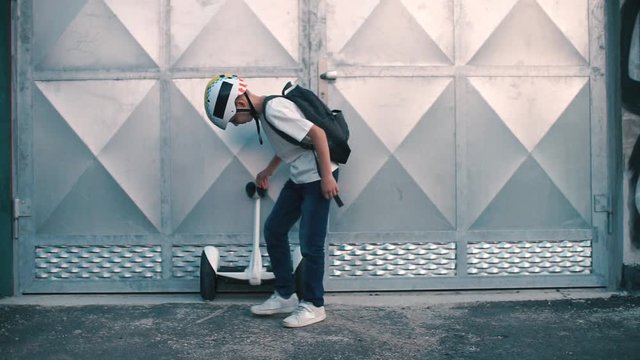 the boy walks up to the segway and drives away on it