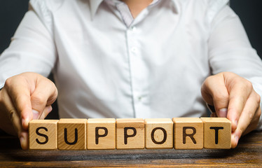 A man holds the word Support. Providing business assistance and support at all stages of startup...