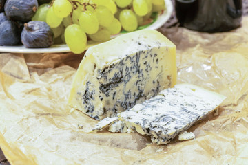 Gorgonzola cheese with blue mold and green grapes. Rustic dinner in vintage style