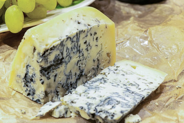 Gorgonzola cheese with blue mold and green grapes. Rustic dinner in vintage style