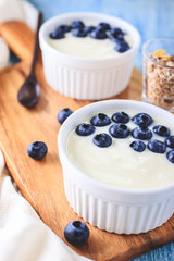 Yogurt with fresh blueberries on wooden background. Health concept.