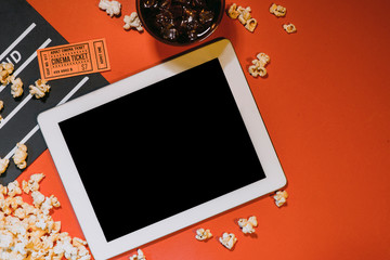 Blank digital tablet, popcorn, filmstrip, cinema and movie online streaming concept