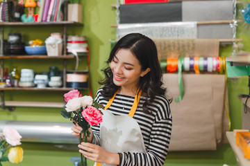 Happy beautiful young woman florist  standing in flower shop