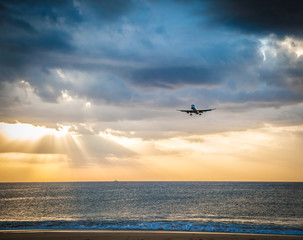 Fototapeta na wymiar Landing plane in Sunset on the beach of Phuket