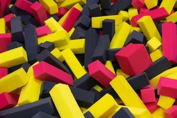 Pool in the kid game center filled by yellow red and black cubes