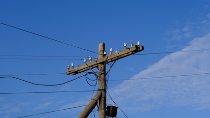  Electric pole with wires against the blue sky