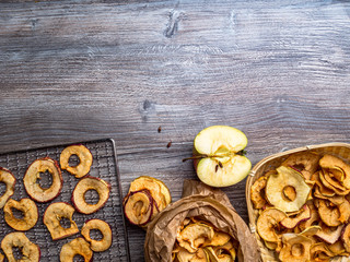 tasty apple chips and fresh apple on wooden background, free space for text