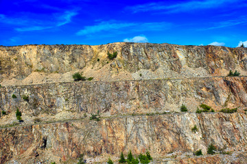 abandoned huge quartz qarry in mountains on the sky background
