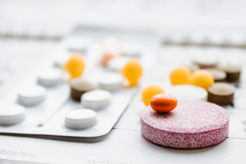 A bunch of different pills on a calendar background. Pills, supplements and medicines for the disease.