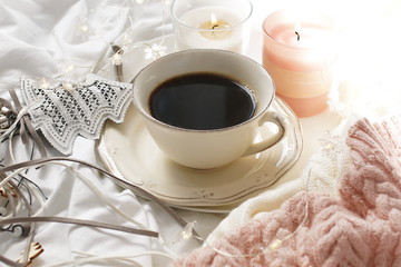 Fflat lay Christmas background in hygge style. cup of coffee, candles, warm plaid and New Year decoration. Winter holiday concept.Home working cozy lifestyle in a bed.