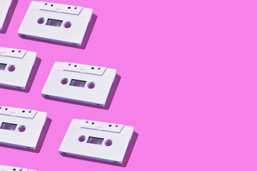 Obraz premium Pattern of audio cassette with copy space. Vintage white audio cassette tap on colored background. Old cassette tape audio isolated.