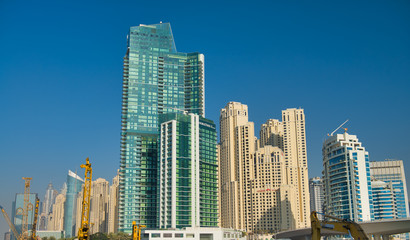 Naklejka na ściany i meble DUBAI, UAE - DECEMBER 2016: Exterior view of modern city buildings. Dubai is a major tourist attraction