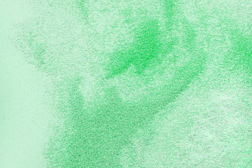 Many multi-colored spangles are scattered on a mint background. Neo color. View from above. Place...