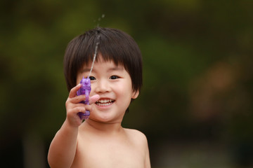 水鉄砲で遊ぶ男の子