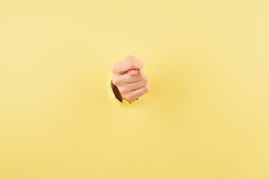 Woman showing a fig sign on yellow background copy space closeup