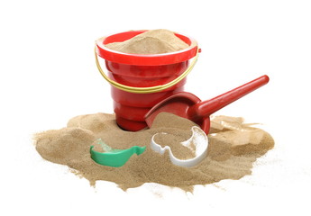Beach toys for kids, plastic tools in sand pile isolated on white background