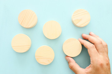 business concept of man hand arranging wooden round blocks. mock up or template