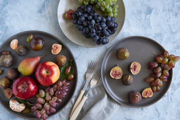 healthy organic fruits in plates apple grapes fig plums tangerines