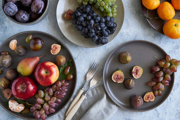 healthy organic fruits in plates apple grapes fig plums tangerines