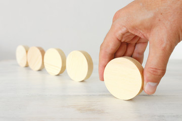 business concept of man hand arranging wooden round blocks. mock up or template