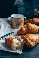 close up of croissants and plum jam on wooden table